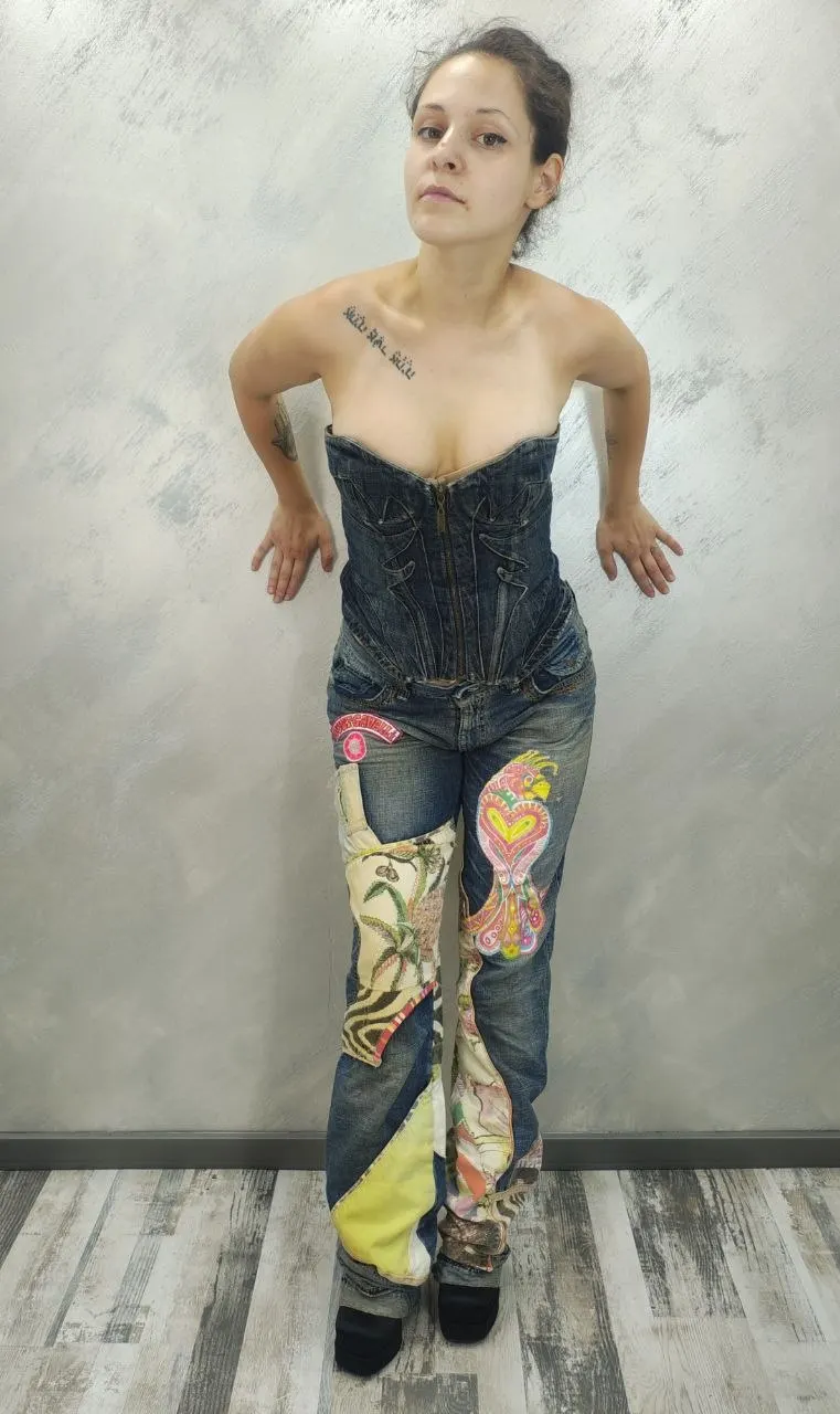 Front view of a strapless Just Cavalli denim corset featuring multi-fabric patchwork, animal prints, and a large embroidered red parrot