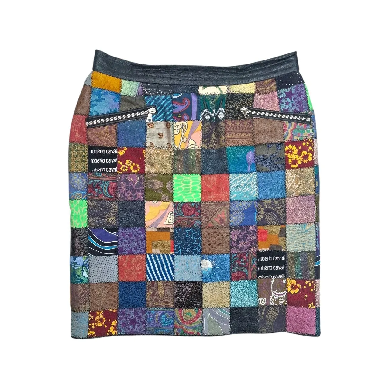 Front view of a 90s vintage Roberto Cavalli leather mini skirt featuring a solid black waistband, diagonal zipper pockets, and multicolor patchwork panels